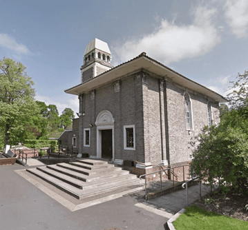 Exterior view of Honor Oak Crematorium, an Italianate style brick building with ornate chimney tower, surrounded by trees 